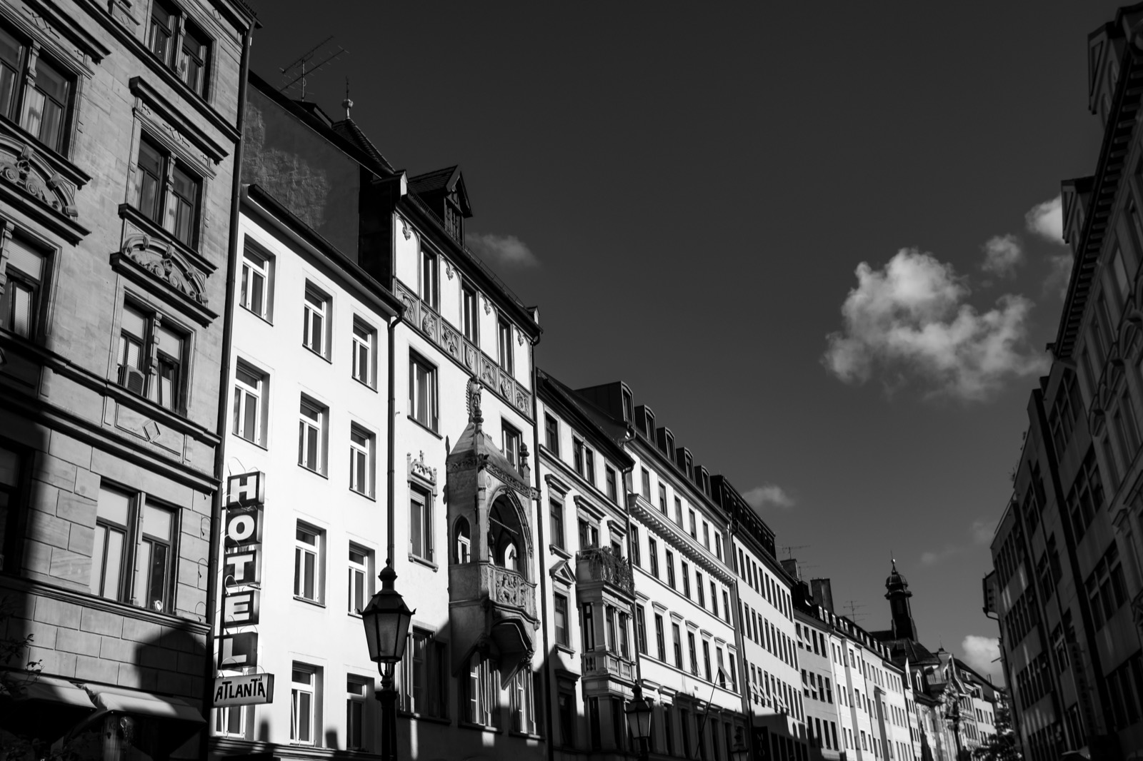 A quiet residential street in Munich with Altbau buildings, bicycles, and trees in spring bloom
